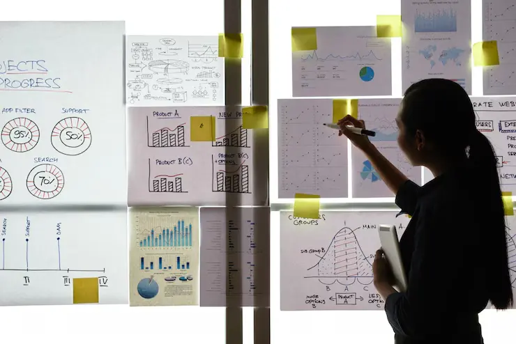 Asian woman reviewing business graphs by office window